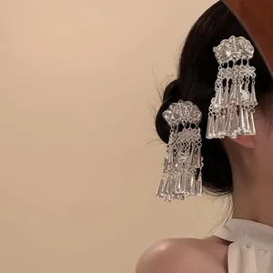 Détail de pinces à cheveux argentées ornées de fleurs papillons et de glands sur cheveux
