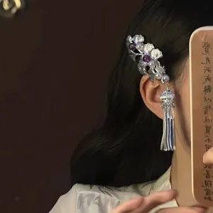 Détail d'une pince à cheveux ginkgo argentée élégante avec perles mauves et gland