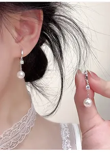 Elegant silver hoop earrings with zircon and white pearl drop pendants detail shot