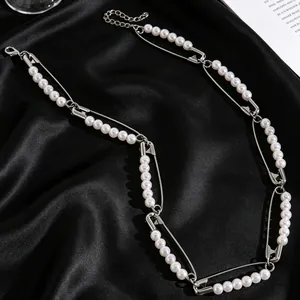 Detalle del collar estilo hip-hop con imperdibles plateados y perlas de imitación