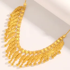 Primo piano di collana dorata multistrato con frange a piuma e dettagli di sfere oro