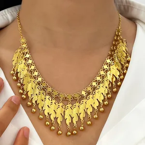 Dettaglio di una collana con nappine a piuma d'oro pesante su modello per abbigliamento da sera