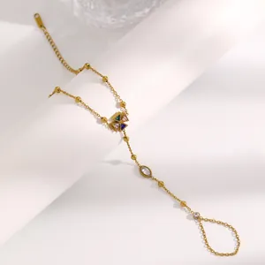 Gros plan d'un bracelet de doigt en acier inoxydable doré avec zircons multicolores