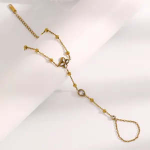 Détail d'un bracelet de main en acier inoxydable doré avec des charmes en cristal fin