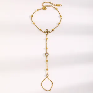 Détail du bracelet de doigt en acier inoxydable doré avec chaîne à billes et fleur