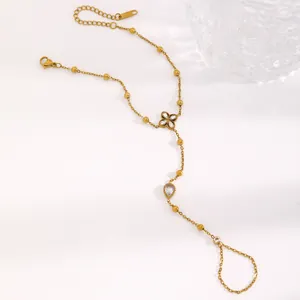 Vue détaillée d'un bracelet bague en acier inoxydable doré avec des breloques fleurs et pierres.
