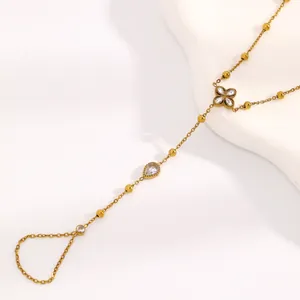 Détail du bracelet de doigt en acier inoxydable doré avec trèfles et gouttes d'eau