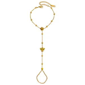Détail exquis d'un bracelet de doigt en acier doré avec breloques papillon et rose