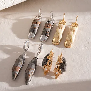 Close-up of irregular resin faux stone earrings with geometric silver needle design