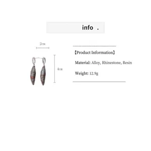 Close-up detail showing 4cm drop earrings with stone texture and material information