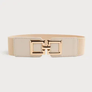 Close-up of a stylish beige elastic wide belt featuring a decorative gold square buckle detail