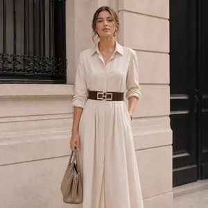 Detail view of a wide brown belt with a gold square buckle on an elegant dress.