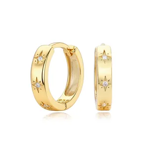 Detail view of gold S925 silver hoop earrings with engraved stars and zircon stones.