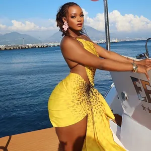Vibrant yellow cheetah print backless asymmetrical mini dress worn by model at sea