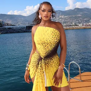 Stunning outdoor detail of a yellow leopard print one-shoulder ruffled mini dress by the sea.