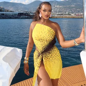 Detailed view of yellow leopard print pleated mini dress worn by model on sunny yacht
