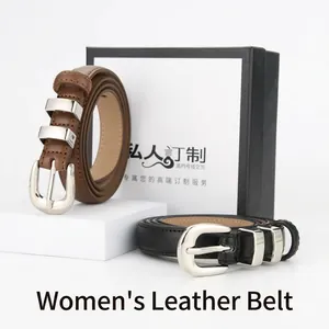 Detailed view of women's brown and black cowhide leather belts with silver buckles