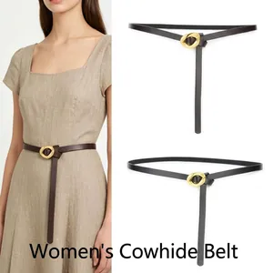 Detail view of a genuine leather thin belt for women with a circular gold buckle.
