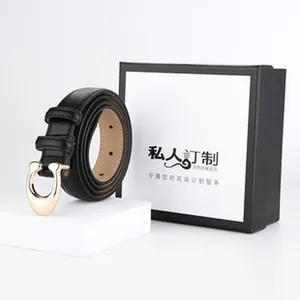 Detailed view of a slim black leather belt with a premium gold horseshoe-style buckle