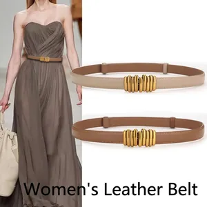 Macro detail of genuine leather thin belts featuring elegant wavy gold metal buckles
