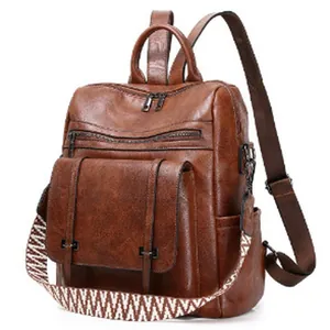 Close-up of the vintage brown PU leather texture and decorative strap on a ladies backpack