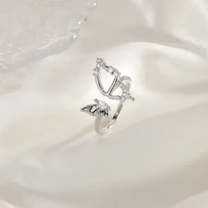 Close-up detail of an elegant silver butterfly ring with cubic zirconia on white silk