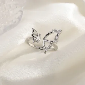 Elegant silver butterfly ring with sparkling zircons on a white silk background.