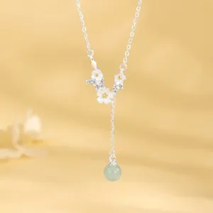 Detailed view of a dainty S925 silver daisy flower necklace with a green bead pendant.