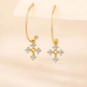 Elegant gold cross dangle earrings set with sparkling stones detail view