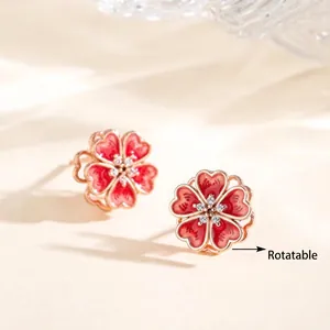 Close-up of rotatable pink enamel flower stud earrings with moissanite