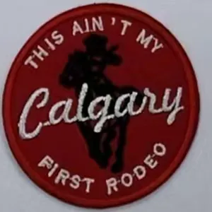 Makro-Detail des roten Calgary First Rodeo Stick-Patches mit Cowboy-Silhouette