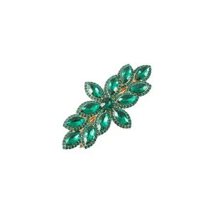 Detailed view of elegant green crystal leaf hair clip with shiny rhinestones in gold