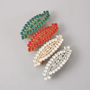 Close-up view of four leaf-shaped hair clips encrusted with vibrant colorful crystals