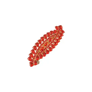 Close-up detail of red rhinestone leaf-shaped spring hair clip with gold base