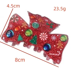 Detailed view of 8cm red glitter Christmas hair claw clip with festive gingerbread man motifs