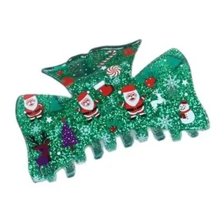Detailed macro view showing a festive green glitter hair claw clip with classic Christmas icons