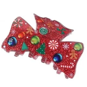 Detail shot of Christmas red glitter hair claw clip with gingerbread man and tree icons.