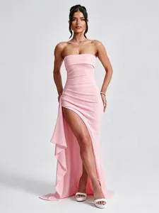 Elegant pink strapless maxi dress featuring a high side slit and ruffled asymmetric hem.