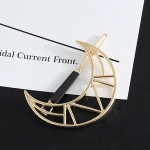 Detailed view of a geometric hollow gold moon hair clip featuring a minimalist design