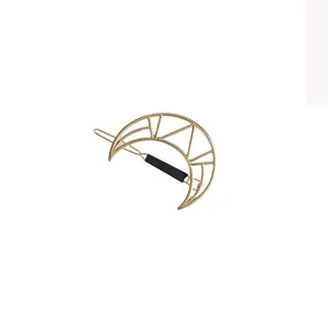 Macro view of gold geometric crescent moon hair clip with minimalist line design