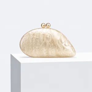 Close-up detail of asymmetric acrylic evening clutch bag with pearlescent marble texture