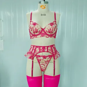 Dettaglio del set di lingerie rosa con ricamo floreale, reggicalze e calze abbinate