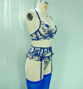 Dettaglio di un set reggiseno e reggicalze ricamato con fiori blu su un manichino