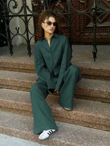 Detailed view of dark green loose linen long sleeve shirt and wide leg trousers casual set