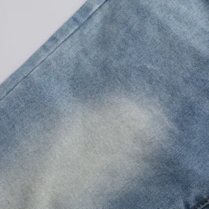 Gros plan sur la texture du tissu denim extensible délavé bleu clair pour jean homme