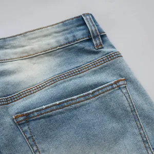 Détail montrant la texture et la poche d'un jean en denim extensible bleu clair pour homme.