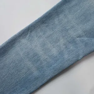Vue macro détaillée montrant la texture du tissu denim bleu clair avec finition délavée