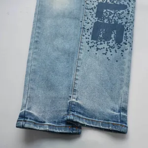 Gros plan de l'ourlet de jean bleu avec motif de taches de peinture et bord usé