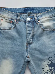 Gros plan sur un jean en denim bleu clair extensible pour homme avec motif de taches d'encre