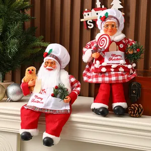 Gros plan des figurines en peluche du Père Noël et de la Mère Noël sur la cheminée.